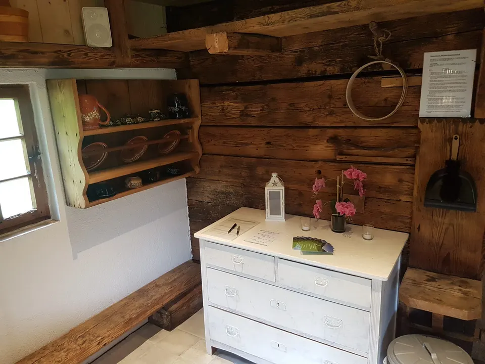 Ecke im Eingangsraum mit Kommode, Laterne, Orchidee und Wandregal mit Geschirr
