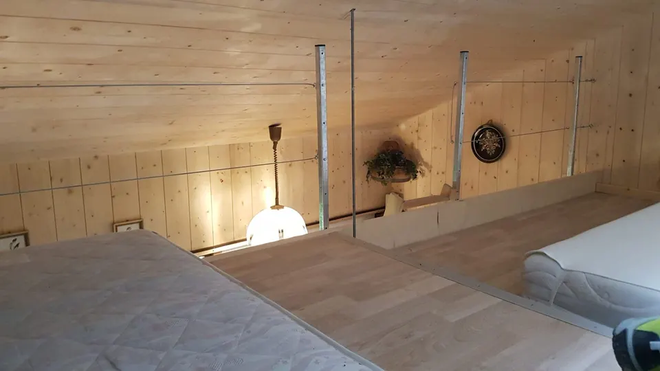 Schlafgalerie unter dem Dach mit Matratzen, Geländer und hellem Holztäfer