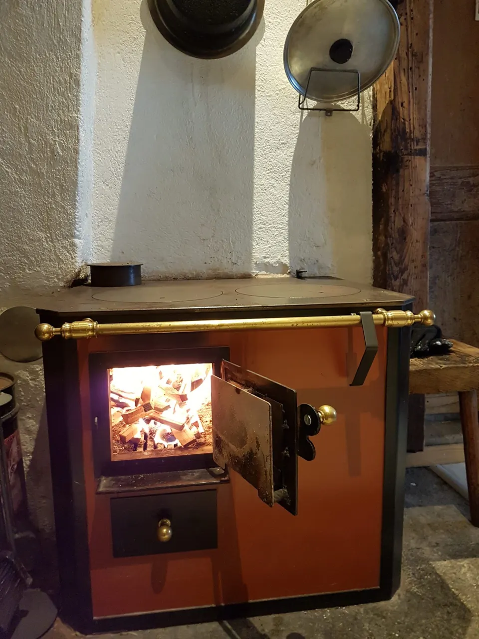 Holzherd mit brennendem Feuer und offener Feuerraumtür
